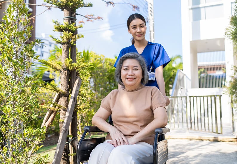 Skilled Nurse Helping Elderly Woman Navigate Around Dementia Care Facility Skilled Nurse Helping Elderly Woman Navigate Around Dementia Care Facility