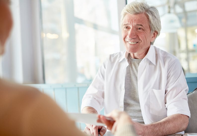 Elderly Man Talking to Friend Inside Memory Care Facility Elderly Man Talking to Friend Inside Memory Care Facility
