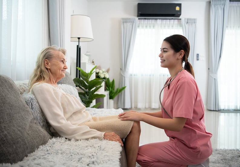Skilled Nurse Aiding Elderly Woman inside Memory Care Facility Skilled Nurse Aiding Elderly Woman inside Memory Care Facility