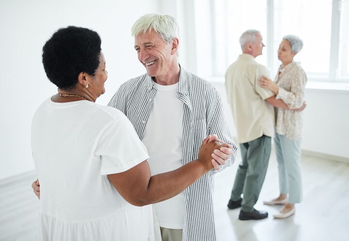 Two Elderly Couples Dancing inside Assisted Living Facility Two Elderly Couples Dancing inside Assisted Living Facility