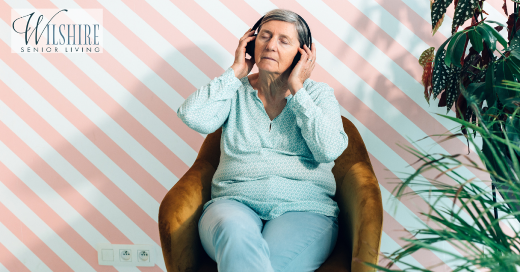 senior-old-lady-sitting-in-comfortable-chair-listening-to-music-1024x536