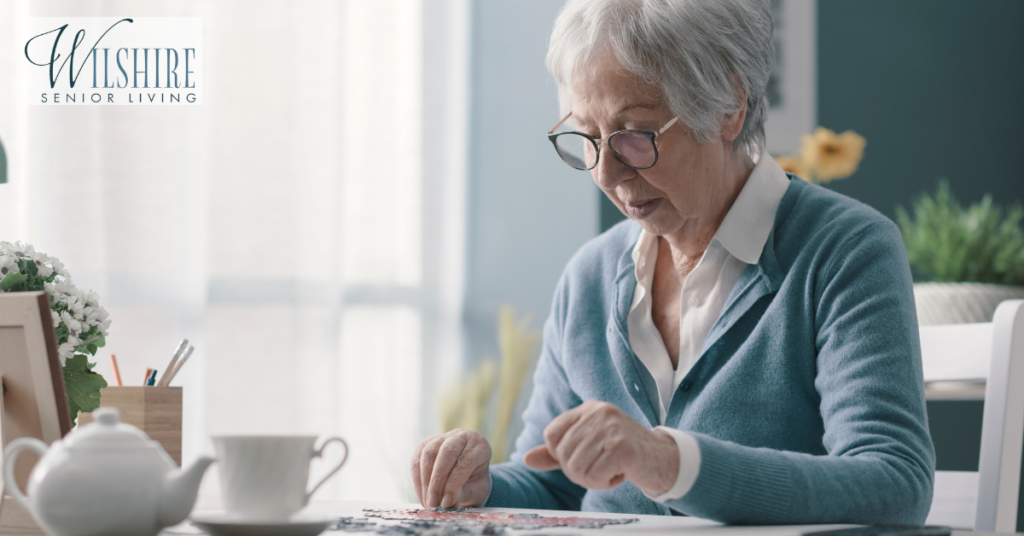 senior-woman-sitting-at-desk-and-solving-a-puzzle-1024x536